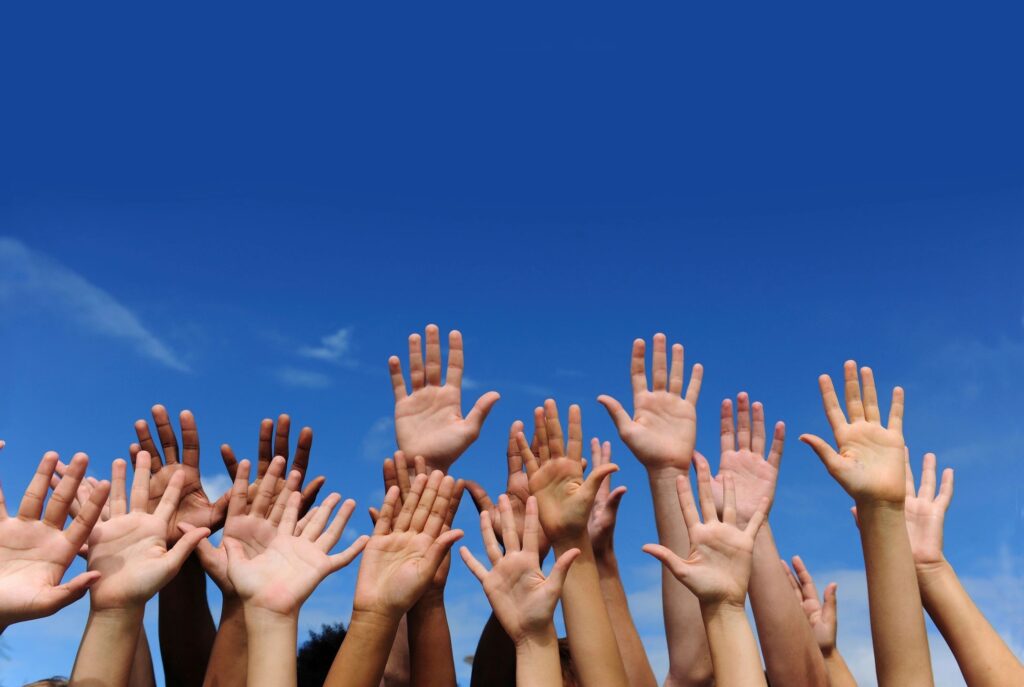 A mixture of hands from people of different colours, representing diversity and inclusion.